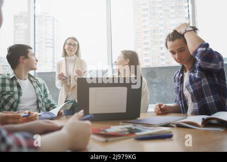 Glückliche Studenten genießen es, von ihrer erfahrenen Professorin zu lernen und Spaß im Unterricht zu haben Stockfoto