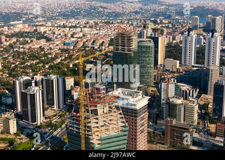 Eine Luftperspektive auf das geschäftige Levent-Viertel in Istanbul mit unterbauten Wolkenkratzern, Bürotürmen und einem sichtbaren Kran. Stockfoto