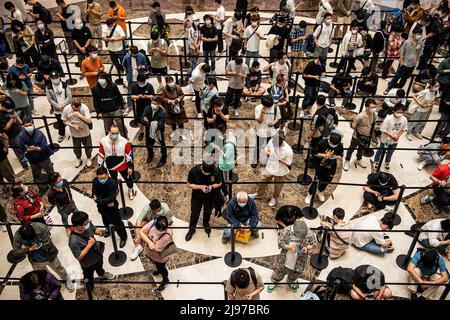 Wuhan, China. 21.. Mai 2022. Bei der offiziellen Eröffnung des neuen Apple Stores auf der Wuhan International Plaza, Wuhan, warten maskierte Menschen in der Schlange. Apple eröffnete seinen ersten Flagship-Store in Wuhan, ebenfalls den 54. Flagship-Store im Großraum China. Kredit: SOPA Images Limited/Alamy Live Nachrichten Stockfoto