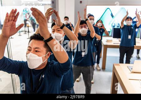 Wuhan, China. 21.. Mai 2022. Maskierte Apple-Mitarbeiter begrüßen Kunden bei der Eröffnung eines neuen Stores in Wuhan, der chinesischen Provinz Hubei. Apple eröffnete seinen ersten Flagship-Store in Wuhan, ebenfalls den 54. Flagship-Store im Großraum China. Kredit: SOPA Images Limited/Alamy Live Nachrichten Stockfoto