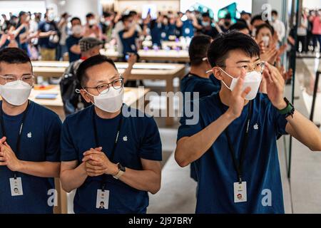 Wuhan, China. 21.. Mai 2022. Maskierte Apple-Mitarbeiter begrüßen Kunden bei der Eröffnung eines neuen Stores in Wuhan, der chinesischen Provinz Hubei. Apple eröffnete seinen ersten Flagship-Store in Wuhan, ebenfalls den 54. Flagship-Store im Großraum China. Kredit: SOPA Images Limited/Alamy Live Nachrichten Stockfoto