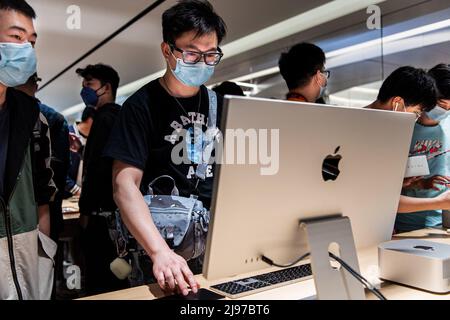 Wuhan, China. 21.. Mai 2022. Chinesische Kunden mit Masken testen bei der offiziellen Eröffnung des neuen Apple Stores auf der Wuhan International Plaza, Wuhan, einen iMac. Apple eröffnete seinen ersten Flagship-Store in Wuhan, ebenfalls den 54. Flagship-Store im Großraum China. Kredit: SOPA Images Limited/Alamy Live Nachrichten Stockfoto