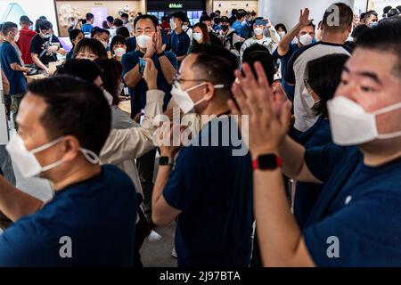 Wuhan, China. 21.. Mai 2022. Maskierte Apple-Mitarbeiter begrüßen Kunden bei der Eröffnung eines neuen Stores in Wuhan, der chinesischen Provinz Hubei. Apple eröffnete seinen ersten Flagship-Store in Wuhan, ebenfalls den 54. Flagship-Store im Großraum China. Kredit: SOPA Images Limited/Alamy Live Nachrichten Stockfoto