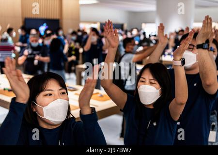 Wuhan, China. 21.. Mai 2022. Maskierte Apple-Mitarbeiter begrüßen Kunden bei der Eröffnung eines neuen Stores in Wuhan, der chinesischen Provinz Hubei. Apple eröffnete seinen ersten Flagship-Store in Wuhan, ebenfalls den 54. Flagship-Store im Großraum China. Kredit: SOPA Images Limited/Alamy Live Nachrichten Stockfoto