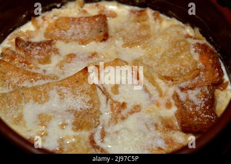 Traditionelle arabische ägyptische östliche Dessertküche namens Om Ali, ägyptisches Brot Pudding in einer braunen Schüssel Töpfereiauflauf aus Milch, ägyptische bre Stockfoto