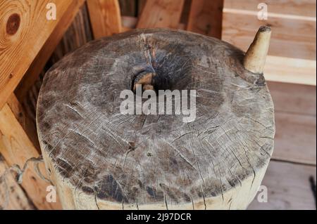 Eine alte Handmühle aus Steinen und Holz. Mehlschleifvorrichtung. Authentisches Kunsthandwerk Stockfoto