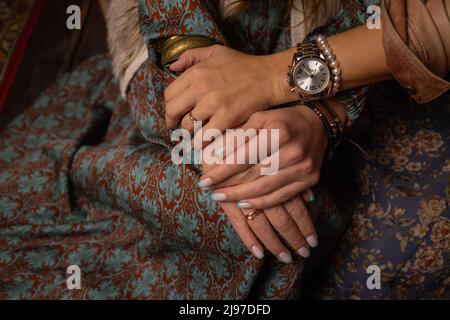 Nahaufnahme einer Stützhand. Nahaufnahme einer jungen Frau, die die Hände eines älteren Mannes bequem in der Hand hält. Weibliche Betreuerin, die die Hände eines älteren Mannes hält Stockfoto