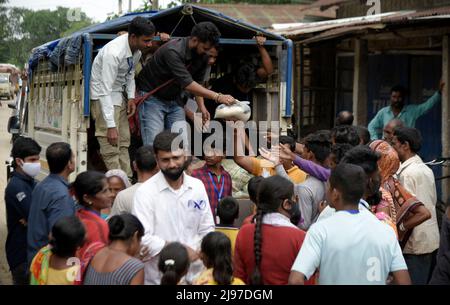 Assam, Indien. 20.. Mai 2022. Freiwillige verteilen am 20. Mai 2022 in Nagaon, Assam, Indien, Lebensmittel an überflutete Menschen, die durch starke Regenfälle überflutet wurden. Mindestens 10 Menschen sind bei Überschwemmungen und Erdrutschen aufgrund von Regenfällen vor dem Monsun in Assam ums Leben gekommen. Kredit: David Talukdar/Alamy Live Nachrichten Gutschrift: David Talukdar/Alamy Live Nachrichten Stockfoto