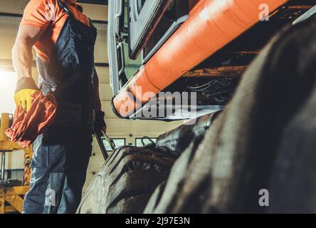 Moderne Bagger oder Raupenreparatur durchgeführt von Kaukasischen Professional Heavy Construction Machines Mechanic in seinem 40s. Stockfoto