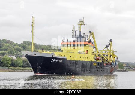 The Marina, Cork, Irland. 21.. Mai 2022. Ein Ruderer auf dem River Lee am frühen Morgen, als das Fischereiforschungsschiff Tridens den Kanal hinauf zu einem Liegeplatz am Horgan's Quay, Cork, Irland, fährt. - Credit; David Creedon / Alamy Live News Stockfoto