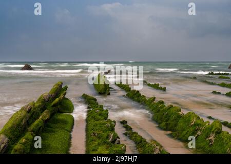 Eine lange Sicht auf die Felsformationen von Flysch bei Ebbe am Strand von Barrika in der Nähe von Bilbao Stockfoto