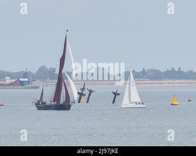 Sheerness, Kent, Großbritannien. 21.. Mai 2022. Die 3 Masten der Thames-Schiffswrack-SS Richard Montgomery wurden vor der Entfernung zum letzten Mal von Thames-Segelbohnen überfahren, die beim historischen jährlichen Medway Barge Sailing Match gegeneinander antreten. Die 3 Masten sollen in diesem Jahr abgeschaltet werden, die Arbeiten sollen im Juni beginnen. Das Schiffswrack sank 1944 mit 1400 Tonnen Sprengstoff an Bord. Kredit: James Bell/Alamy Live Nachrichten Stockfoto