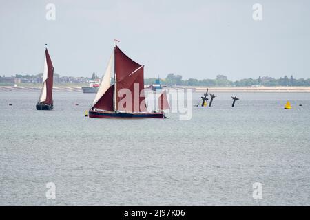 Sheerness, Kent, Großbritannien. 21.. Mai 2022. Die 3 Masten der Thames-Schiffswrack-SS Richard Montgomery wurden vor der Entfernung zum letzten Mal von Thames-Segelbohnen überfahren, die beim historischen jährlichen Medway Barge Sailing Match gegeneinander antreten. Die 3 Masten sollen in diesem Jahr abgeschaltet werden, die Arbeiten sollen im Juni beginnen. Das Schiffswrack sank 1944 mit 1400 Tonnen Sprengstoff an Bord. Kredit: James Bell/Alamy Live Nachrichten Stockfoto