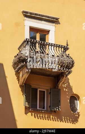 Nahaufnahme eines schönen Balkons mit altem schmiedeeisernem Geländer in Brescia Downtown, Lombardei, Italien, Europa. Stockfoto