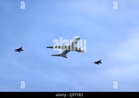 MOSKAU, RUSSLAND - 7. MAI 2022: Weltuntergangsflugzeug Il-80 (Maxdome), begleitet von zwei Kampfjets, fliegt bei einer Parade-Probe in blauem Himmel über Moskau Stockfoto