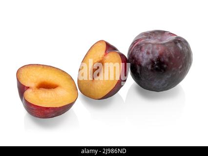 Schwarze Pflaumen isoliert auf Weiß, ein Ganzes und ein Schnitt in die Hälfte. Beschneidungspfad Stockfoto