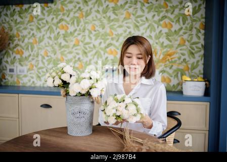 Eine asiatische Frau arrangiert Blumen. Stockfoto