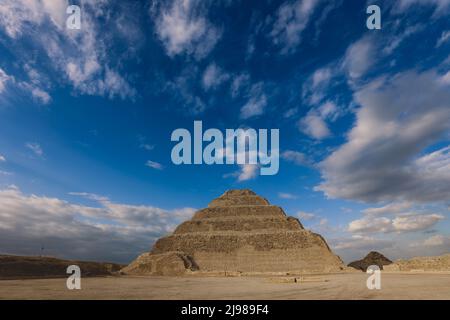 Majestätischer Blick auf die Stufenpyramide von Djoser unter blauem Himmel, ist eine archäologische Stätte in der Nekropole von Saqqara, nordwestlich der Stadt Memphis Stockfoto