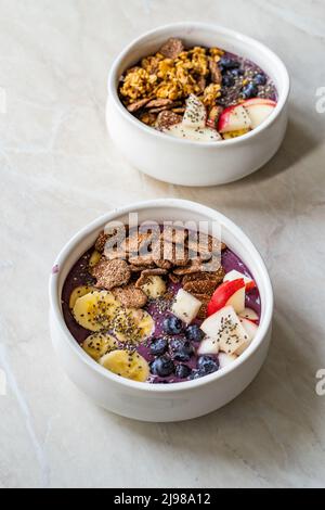 Smoothie Bowl mit Müsli, Getreidekörnern, Chia Seeds, Apfel und Heidelbeeren. Bereit zum Essen. Stockfoto