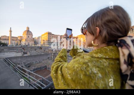 Frau, die das Forum Romanum fotografiert, während sie in Rom unterwegs ist Stockfoto