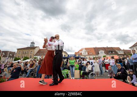 Ostritz, Deutschland. 21.. Mai 2022. Eine Frau und ein Mann tanzen auf dem Laufsteg zur Modenschau, die das Thema Demokratie, Kosmopolitismus und Toleranz trägt. Das Friedensfestival ist seit Jahren ein integraler Bestandteil der Gemeinschaft, um sich gegen rechtsorientierte Veranstaltungen in der Stadt zu wehren. Quelle: Daniel Schäfer/dpa/Alamy Live News Stockfoto