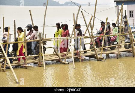 Guwahati, Guwahati, Indien. 20.. Mai 2022. Am Freitag, den 20.. Mai 2022, laufen Menschen durch eine provisorisch gebaute Bambusbrücke, nachdem sie von dem Schiff aus Nord-Guwahati nach Guwahati über den Fluss Brahmaputra am Ufer des Flusses Brahmaputra in Guwahati Assam India heruntergekommen sind.die Fähre von Jorhat nach Majuli wurde wegen einer Zunahme ausgesetzt Vom Wasserstand des Flusses Brahmaputra (Bild: © Dasarath Deka/ZUMA Press Wire) Stockfoto