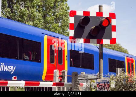Ein Zug der South Western Railway, der den Bahnübergang Vine Road, Barnes, London, SW13, England, VEREINIGTES KÖNIGREICH Stockfoto