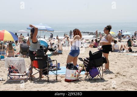 Brooklyn, USA. 21.. Mai 2022. (NEU) überfüllter und warmer Coney Island Beach. 21. Mai 2022, Brooklyn, New York, USA: Am Strand von Coney Island gibt es viele Badegäste, darunter auch Kinder, die während der Frühjahrssaison in Brooklyn das heiße Wetter ausnutzen. Kinder werden am Ufer und im Wasser spielen sehen, während Erwachsene sich entspannen, Romane lesen, Sonnenbräune und andere sich unter Zelten, Sonnenschirmen und Handtüchern verstecken, um sich vor der sengenden Sonne zu verstecken.Quelle: Niyi Fote/Thenews2 (Foto: Niyi Fote/TheNews2/Zumapress) (Bildquelle: © Niyi Fote/TheNEWS2 via ZUMA Press Wire) Stockfoto