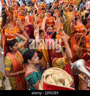 Neu Delhi, Indien April 03 2022 - Frauen mit Kalash am Kopf während des Jagannath-Tempels Mangal Kalash Yatra tragen indische Hindu-Anhänger irdische Töpfe Conta Stockfoto