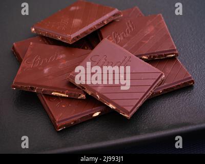Tambow, Russische Föderation - 29. März 2022 Stücke Lindt Schokolade auf schwarzem Teller. Nahaufnahme Stockfoto
