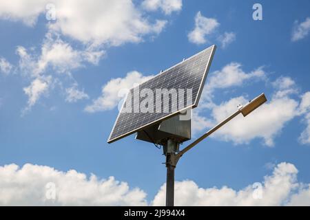 Solarbetriebene Straßenlampe gegen den blauen Himmel Stockfoto