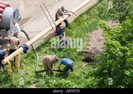 Tiraspol, Moldawien - 17. Mai 2022: Männliche Arbeiter beheben einen Bruch in einer Wasserversorgung und Kanalisationsleitung. Unfall auf der Linie der städtischen Infrastruktur. Mangelhafte q Stockfoto