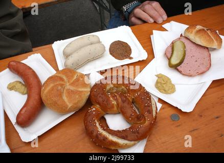 Tisch mit traditionellen österreichischen Speisen bei einem Outdoor-Festival. Stockfoto