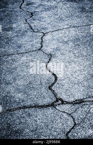 Abstrakter Hintergrund oder Textur breite Risse auf einem dunklen Asphalt Stockfoto