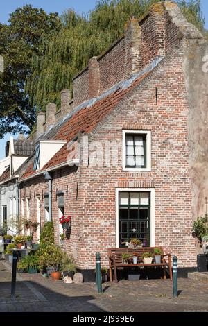 Kleines Haus in der alten mittelalterlichen Festungsstadt Elburg, erbaut gegen die alte Festungsmauer. Stockfoto