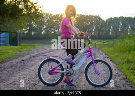 Kind auf dem Fahrrad bei Sonnenuntergang. Stockfoto