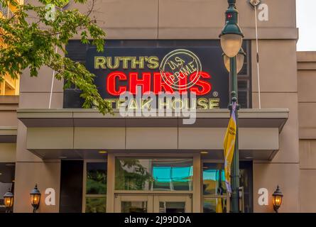 Charlotte, NC/USA - 26. Mai 2019: Außenansicht der Fassade von Ruth's Chris Steak House mit einer Marke in neonbeleuchteten roten Buchstaben und weißen Buchstaben auf schwarzem Hintergrund Stockfoto