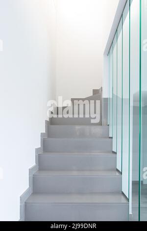 Eine moderne Treppe. Marmortreppe und Glasgeländer. Stockfoto