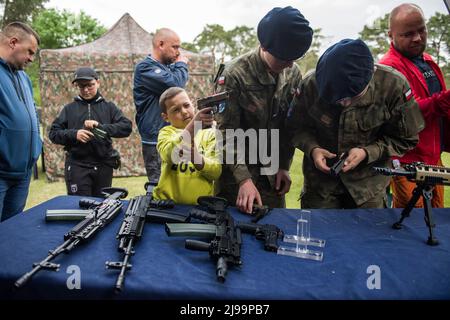 Kozienice, Mazowieckie, Polen. 21.. Mai 2022. Kinder und Erwachsene probieren beim Militär-Picknick Gewehre und Gewehre aus. Die Rekrutierung für den neuen freiwilligen allgemeinen Militärdienst Polens beginnt im Mai 21., da die Regierung versucht, die Größe ihrer Streitkräfte zu verdoppeln. Das Verteidigungsministerium hat Einzelheiten zu den Bedingungen für den einjährigen Dienst bekannt gegeben, einschließlich Gehälter und Leistungen.die Einführung eines freiwilligen grundlegenden Militärdienstes wurde durch das Heimatschutzgesetz vorgesehen, Die ursprünglich von der Regierung im Oktober vorgeschlagen wurde, aber kurz nach der russischen Invasion in das Gesetz unterzeichnet wurde Stockfoto