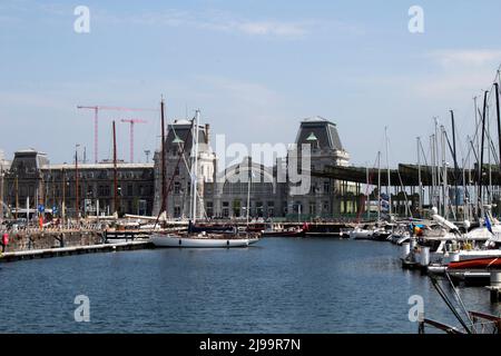 Yachten und Boote in der Jachthaven Oostende Marina mit dem Bahnhof Ostend im Hintergrund Belgien Stockfoto