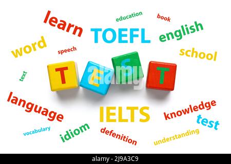Text-TEST aus Holzwürfeln und verschiedenen Wörtern auf weißem Hintergrund. Konzept des Englischstudiums Stockfoto