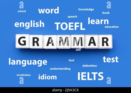 TEXTGRAMMATIK aus Würfeln und verschiedenen Wörtern auf blauem Hintergrund. Konzept des Englischstudiums Stockfoto