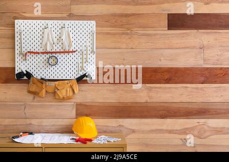 Pegboard und Schreibtisch mit verschiedenen Werkzeugen in der Werkstatt Stockfoto