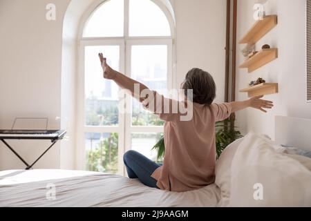 Sorglose ältere Dame, die sich nach dem Schlaf genug voller Energie fühlt Stockfoto