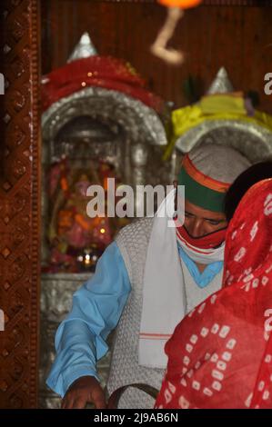 Mandi, Himachal Pradesh, Indien - 10 17 2021: Foto eines Pujari (Priester) mit Gesichtsmaske und Anhänger kam zum Tempel für den Gottesdienst Stockfoto