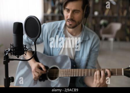 Professioneller Gitarrist spielt Gitarre im heimischen Studio mit spezieller Ausrüstung Stockfoto