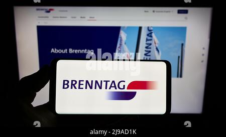 Person, die Smartphone mit Logo des deutschen Chemieunternehmens Brenntag SE auf dem Bildschirm vor der Website hält. Konzentrieren Sie sich auf die Telefonanzeige. Stockfoto