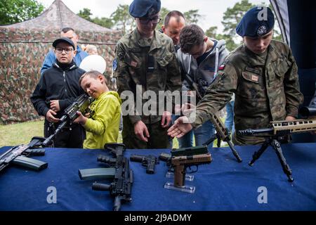 Kozienice, Mazowieckie, Polen. 21.. Mai 2022. Kinder und Erwachsene probieren beim Militär-Picknick Gewehre und Gewehre aus. Die Rekrutierung für den neuen freiwilligen allgemeinen Militärdienst Polens beginnt im Mai 21., da die Regierung versucht, die Größe ihrer Streitkräfte zu verdoppeln. Die Einführung eines freiwilligen grundlegenden Militärdienstes wurde durch das Heimatschutzgesetz vorgesehen, das ursprünglich von der Regierung im Oktober vorgeschlagen, aber kurz nach dem russischen Einmarsch in die Ukraine in Kraft gesetzt wurde. (Bild: © Attila Husejnow/SOPA Images via ZUMA Press Wire) Stockfoto