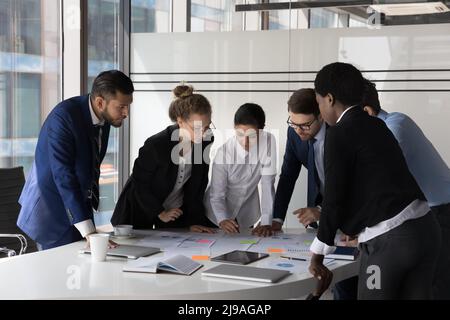 Mitarbeiter verschiedener Rassen arbeiten zusammen und versammeln sich im Sitzungssaal zur Einweisung Stockfoto