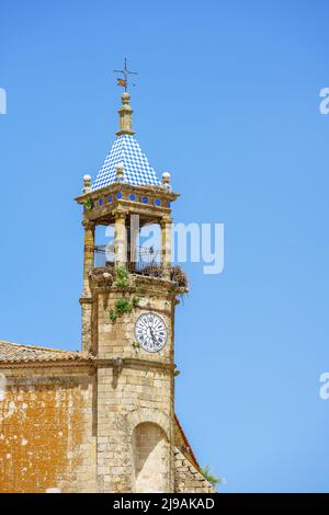 Malerischer Uhrenturm am blauen Himmel mit Storchennestern. Kirche des heiligen Martin, Trujillo, Extremadura, Spanien Stockfoto